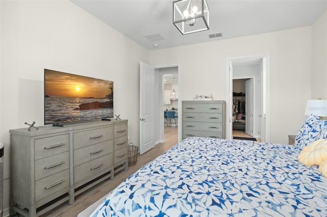 bedroom featuring light hardwood / wood-style floors and a notable chandelier