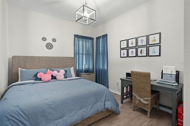 bedroom with a chandelier and hardwood / wood-style floors