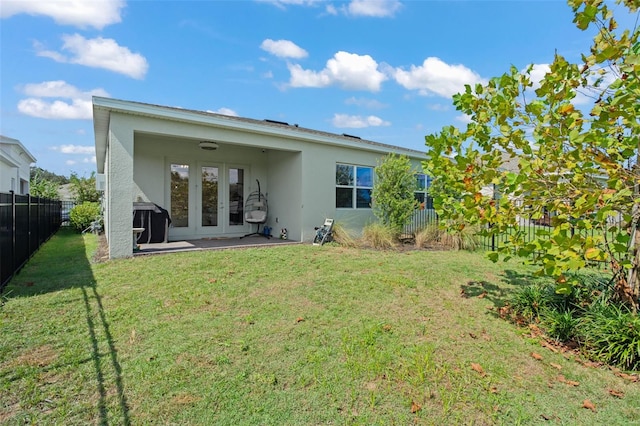 rear view of property with a yard and a patio area