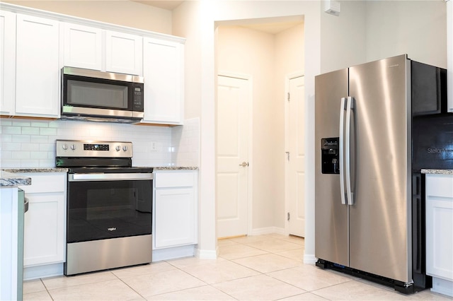 kitchen featuring white cabinets, appliances with stainless steel finishes, and light stone countertops