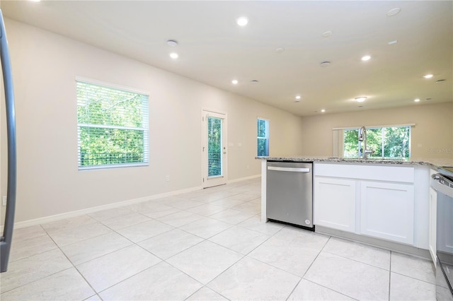 kitchen featuring dishwasher, sink, white cabinetry, light tile patterned floors, and light stone countertops