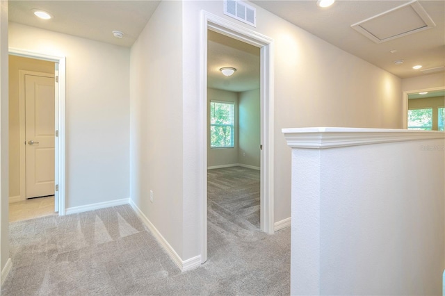 hallway featuring light colored carpet and a wealth of natural light