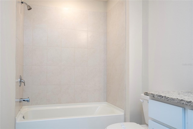 full bathroom with tiled shower / bath, vanity, and toilet