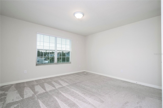 unfurnished room featuring light carpet