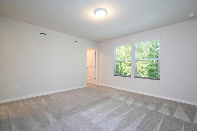 carpeted spare room with a textured ceiling