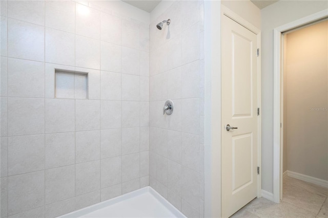 bathroom featuring tile patterned floors and tiled shower