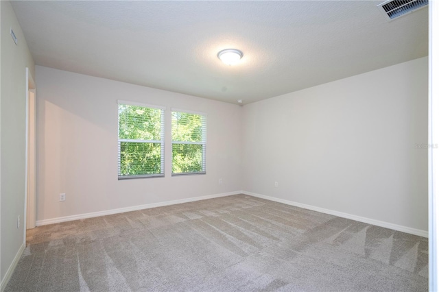 carpeted spare room featuring a textured ceiling