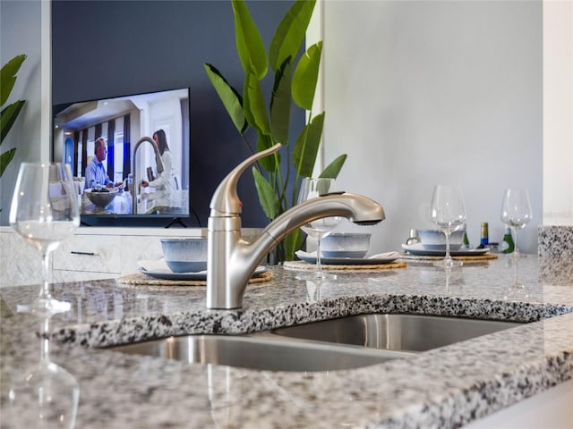 details featuring stone counters and sink