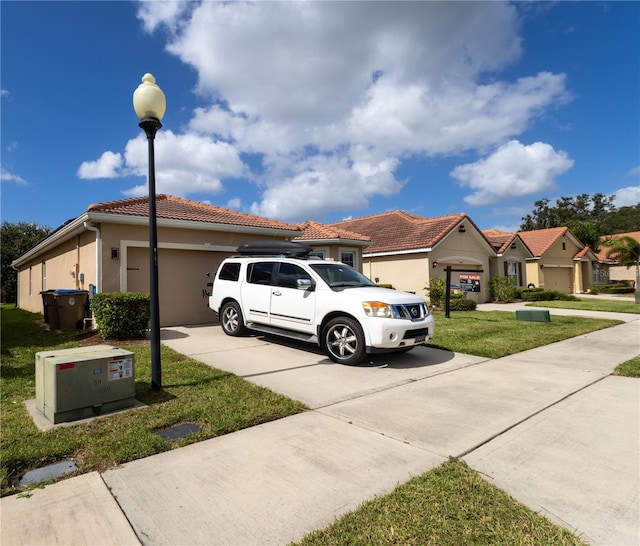 view of front of property featuring a garage and a front lawn