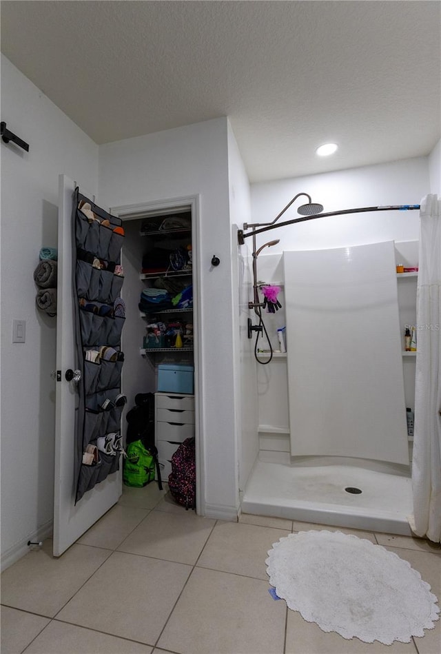 bathroom featuring a shower with shower curtain, tile patterned flooring, and a textured ceiling