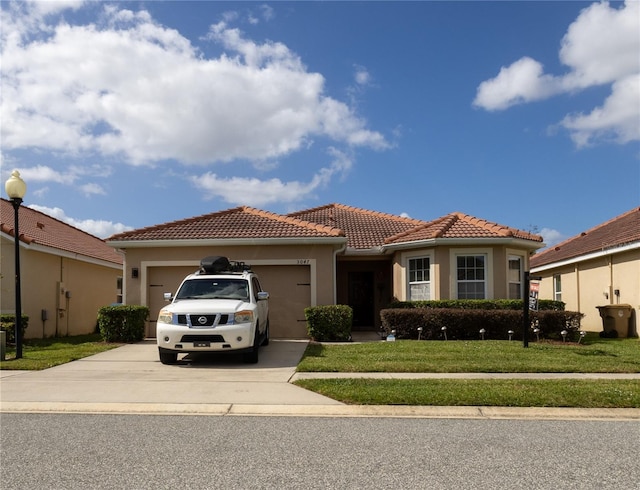 view of front of home featuring stucco siding, a front lawn, driveway, a garage, and a tiled roof