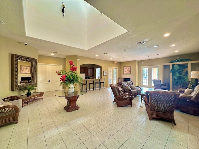 living room featuring light tile patterned flooring, visible vents, recessed lighting, and a fireplace