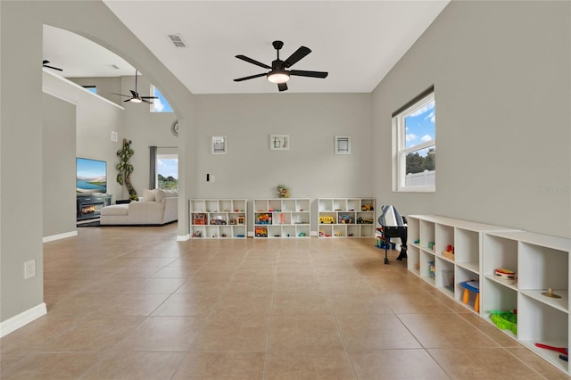 game room featuring visible vents, arched walkways, a ceiling fan, and light tile patterned flooring