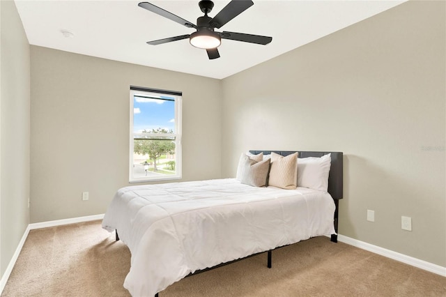 bedroom with light carpet, ceiling fan, and baseboards