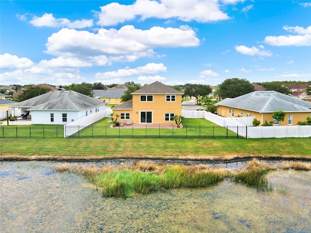 rear view of property with a fenced backyard, a yard, and stucco siding