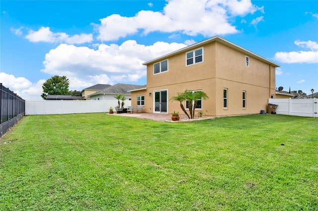 rear view of property featuring stucco siding, a fenced backyard, a lawn, and a patio