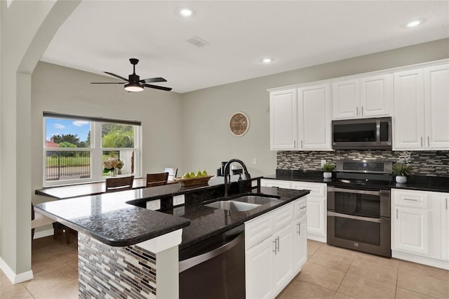 kitchen with white cabinetry, a kitchen island with sink, appliances with stainless steel finishes, and a sink