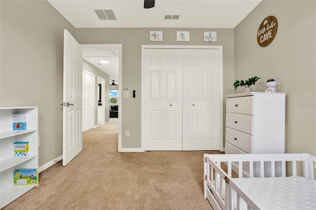 bedroom with baseboards, visible vents, and light colored carpet