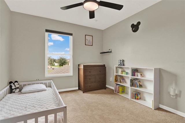 bedroom featuring light carpet, ceiling fan, and baseboards