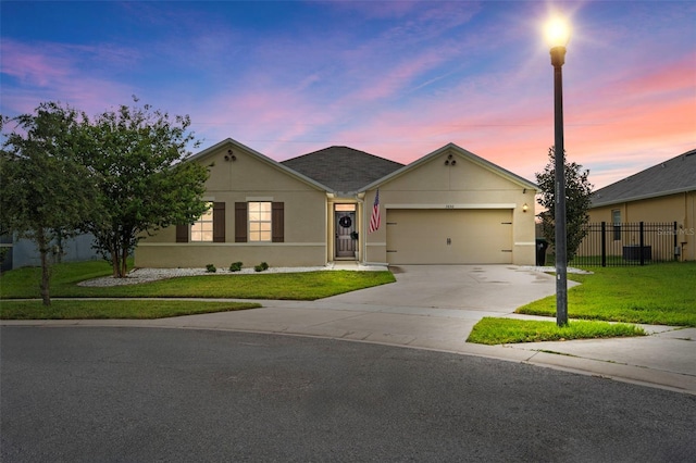 single story home featuring a garage and a lawn