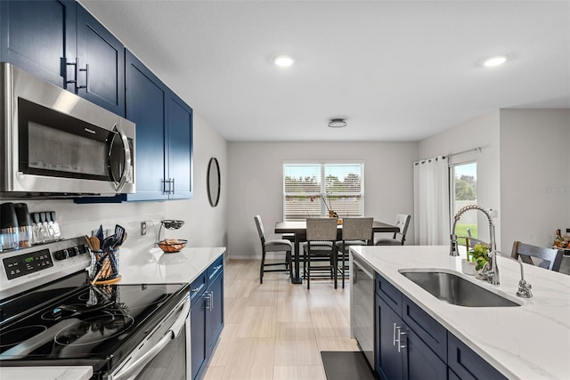 kitchen featuring blue cabinetry, appliances with stainless steel finishes, and sink