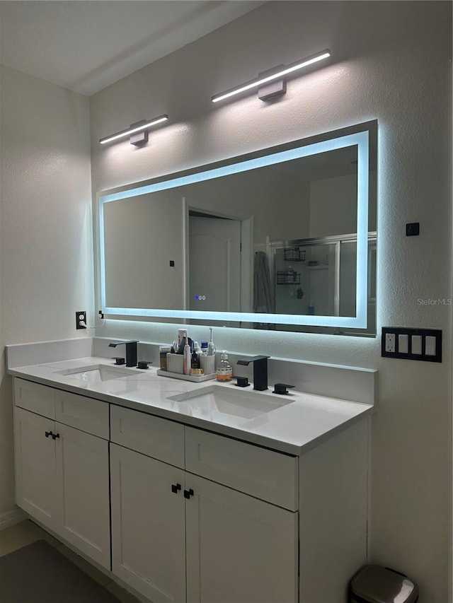 bathroom with vanity and a shower with door