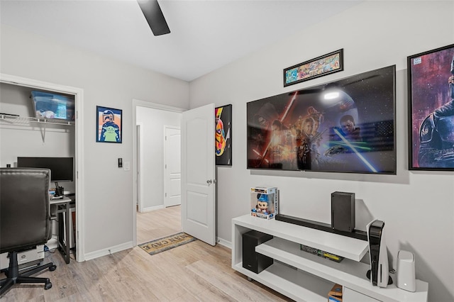 home office with light wood-type flooring and ceiling fan