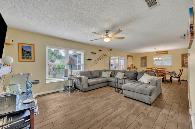 living room featuring ceiling fan, a textured ceiling, and light hardwood / wood-style flooring