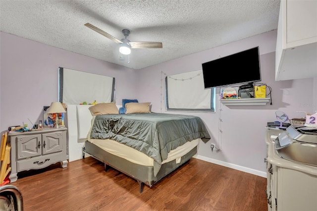 bedroom featuring ceiling fan, hardwood / wood-style floors, and a textured ceiling