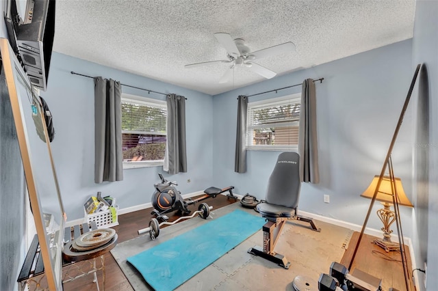 workout room featuring a textured ceiling, plenty of natural light, wood-type flooring, and ceiling fan