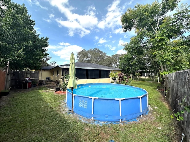 view of pool with a sunroom and a lawn