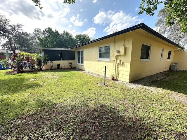 rear view of property with a yard and a sunroom