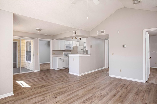 unfurnished living room featuring ceiling fan, a textured ceiling, and light hardwood / wood-style flooring