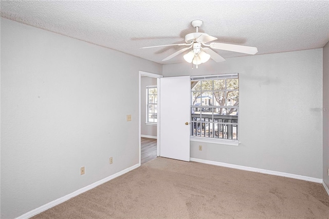 carpeted empty room featuring ceiling fan and a textured ceiling