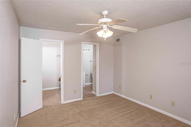 unfurnished bedroom featuring a textured ceiling, ceiling fan, and light colored carpet