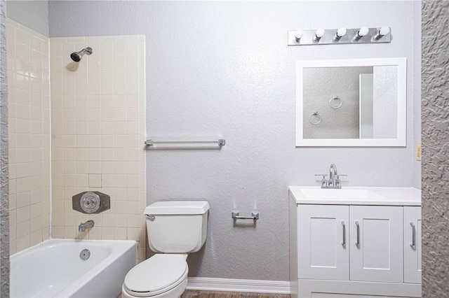 full bathroom featuring tiled shower / bath combo, vanity, and toilet