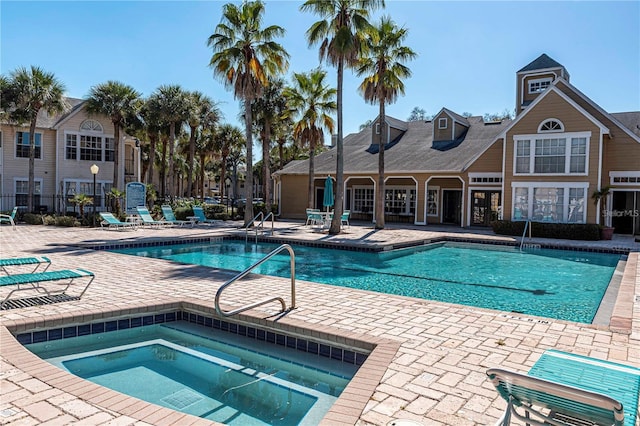 view of swimming pool with a patio and a hot tub