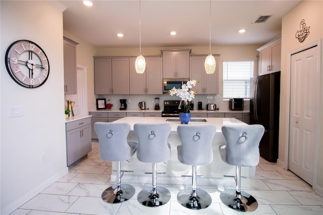 kitchen with decorative light fixtures, a kitchen island, stainless steel appliances, and a breakfast bar