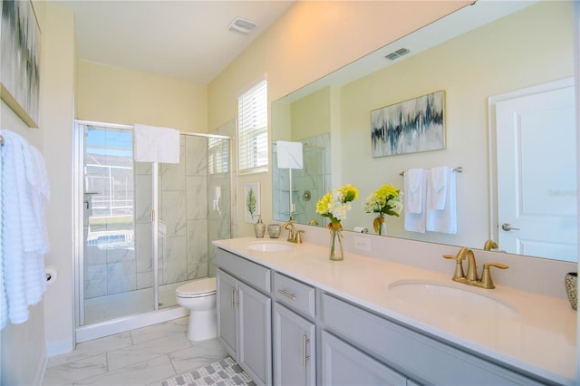 bathroom featuring vanity, a shower with shower door, and toilet