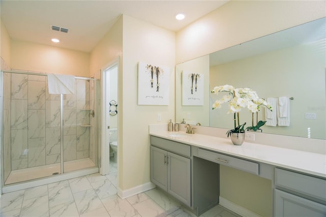 bathroom with vanity, toilet, and a shower with shower door