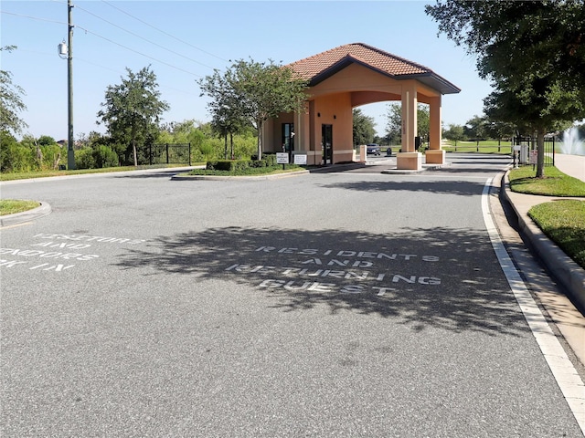8938 Cabot Cliffs Dr, Davenport, FL 33896 - view of asphalt road featuring curbs and a gated entry