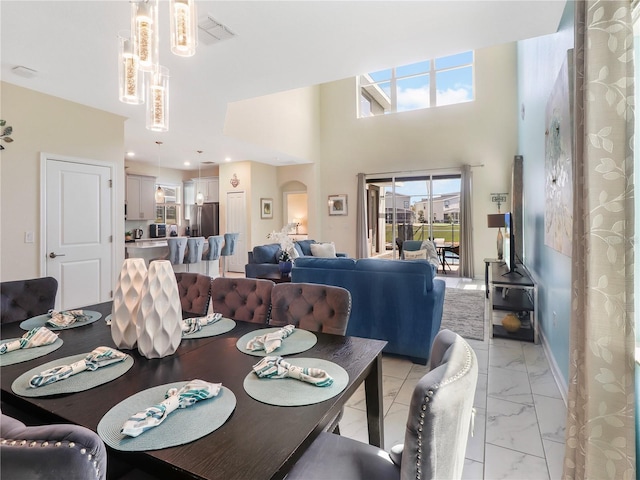 8938 Cabot Cliffs Dr, Davenport, FL 33896 - dining room featuring light marble finish flooring and a towering ceiling