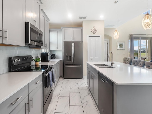 8938 Cabot Cliffs Dr, Davenport, FL 33896 - kitchen with stainless steel appliances, a sink, light marble finish flooring, gray cabinets, and backsplash