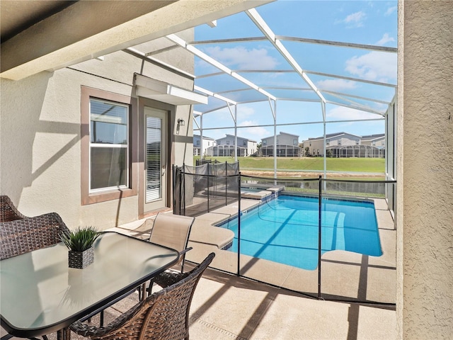 8938 Cabot Cliffs Dr, Davenport, FL 33896 - view of swimming pool featuring a patio area, a pool with connected hot tub, glass enclosure, outdoor dining space, and a residential view