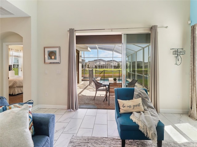 8938 Cabot Cliffs Dr, Davenport, FL 33896 - interior space featuring light marble finish floors, arched walkways, baseboards, and a sunroom