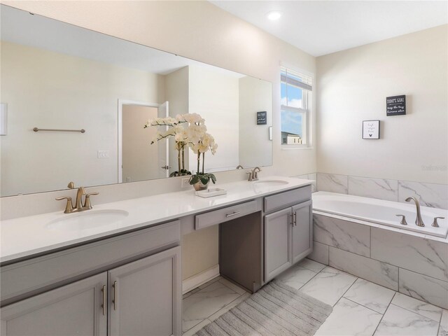 8938 Cabot Cliffs Dr, Davenport, FL 33896 - full bathroom with marble finish floors, double vanity, and a garden tub