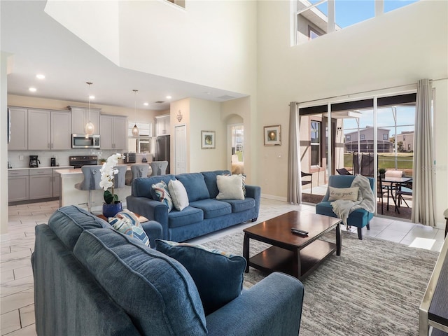 8938 Cabot Cliffs Dr, Davenport, FL 33896 - living area featuring arched walkways, a high ceiling, and recessed lighting