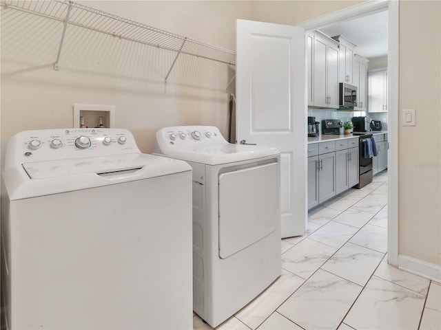 8938 Cabot Cliffs Dr, Davenport, FL 33896 - laundry room with light marble finish flooring, separate washer and dryer, and baseboards