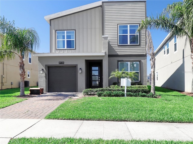 8938 Cabot Cliffs Dr, Davenport, FL 33896 - view of front facade with an attached garage, decorative driveway, a front lawn, and cooling unit