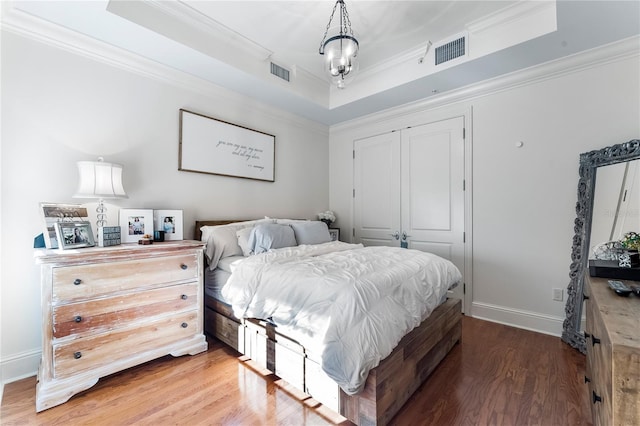 bedroom with crown molding, dark hardwood / wood-style floors, and a closet